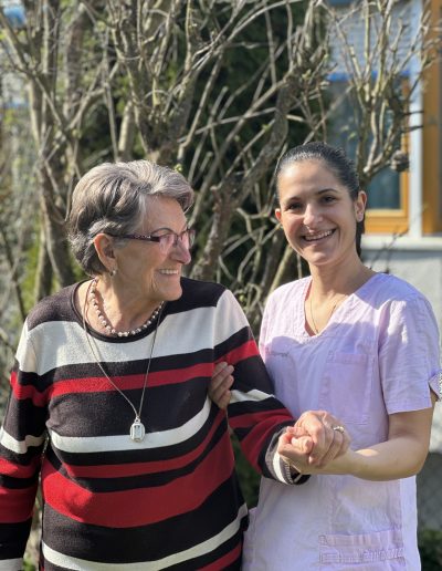 Seniorin wird durch Pflegerin gestützt
