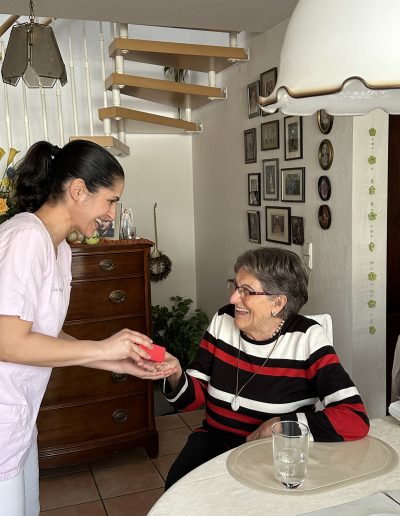 Seniorin und Pflegerin spielen mit einem Ball
