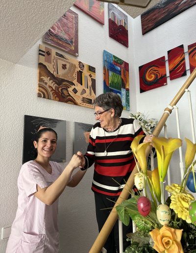 Eine Seniorin wird beim Treppensteigen von einer anderen Person unterstützt