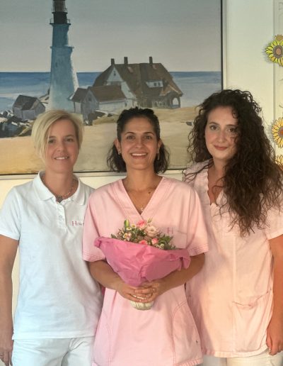 Drei Pflegefachkräfte mit Blumenstraus